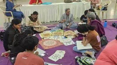 An Indian artist painting intricate patterns on pottery.